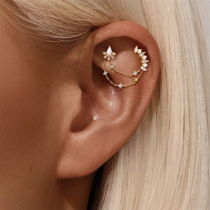 Detail of gold ear cuff set with white crystals and opals on double delicate chains