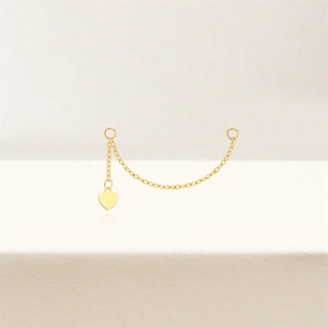 Macro shot of gold S925 sterling silver chain earring with polished heart pendant detail