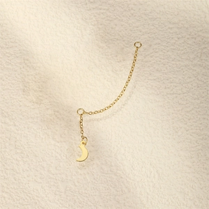 Macro view of long gold chain earrings with crescent moon charms in polished finish