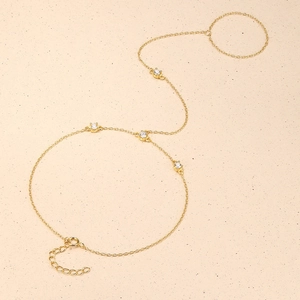 Detalle de pulsera de anillo dorada con cuatro circonitas y cierre de mosquetón seguro