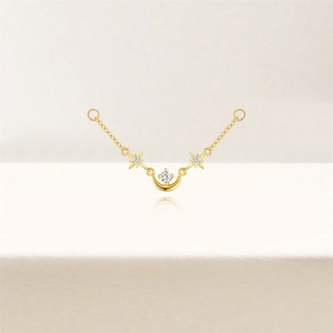 Detail of gold star and crescent moon pendant with sparkling zircon inlays on fine chain