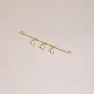 Detail of gold chain earring connector with three sparkling pear-cut zircon pendants