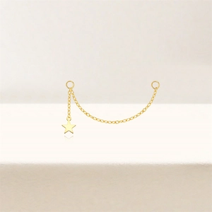 Macro detail of a gold-plated S925 silver link chain with a small star pendant and rings