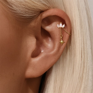 Macro view of gold S925 sterling silver star pendant earring with opal and cubic zirconia