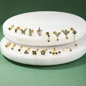 Detaillierte Sammlung von S925 Goldohrringen mit Moosachat auf Marmordisplay