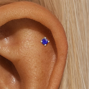 Close-up of S925 sterling silver lapis lazuli stud earring worn on a model's ear cartilage