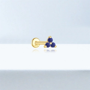 Macro shot of S925 sterling silver ear stud with blue lapis lazuli in gold plating