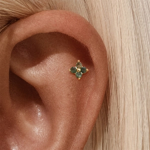 Detailansicht der goldener Blumen-Knorpelstecker mit grünem Moosachat am Ohr der Frau