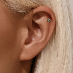 Nahaufnahme eines s925 Silber-Blumenohrrings mit grünem Moosachat am Ohr eines Models