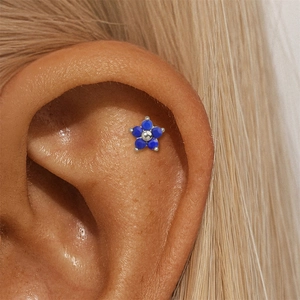 Detail of s925 silver earring with blue lapis lazuli clover flower on ear cartilage
