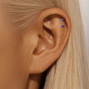 Macro shot of s925 silver helix piercing with two round blue lapis lazuli stones