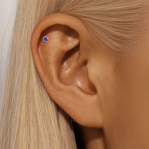 Close-up of s925 silver stud earring with deep blue lapis lazuli on model's ear