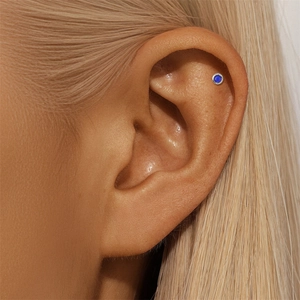 Macro shot of a s925 silver stud with lapis lazuli on the helix piercing of a female ear