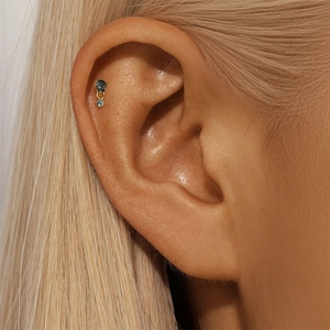 Detailed view of s925 gold moss agate cartilage stud earring worn on the earlobe