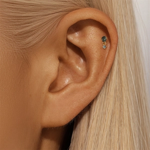 Macro shot of s925 gold moss agate ear stud on ear featuring a natural green gemstone