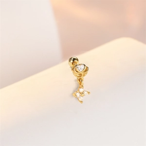 Macro-opname van gouden bloem oorpiercing met hart zirkoon en ster hanger detail