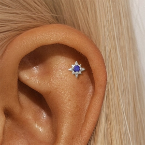 Macro shot of S925 silver starburst earring with blue lapis stone on ear