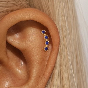Macro view of gold ear climber featuring four round lapis lazuli stones on the ear