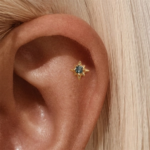 Detailansicht goldener achteckiger Stern-Ohrstecker mit dunkelblauem rundem Edelstein