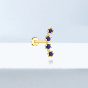 Macro shot of S925 silver gold-plated ear stud with blue lapis lazuli clover gemstones