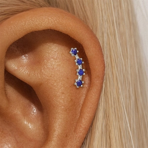 Macro shot of curved s925 silver ear cuff featuring four round blue lapis lazuli stones