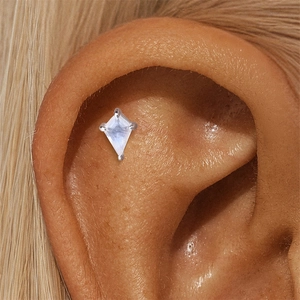 Close-up of kite-cut moonstone stud earring in silver bezel setting on ear