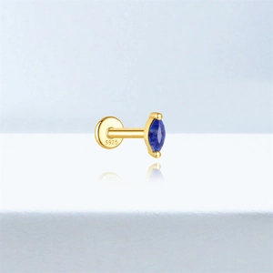 Macro shot of S925 sterling silver stamp on golden labret stud with blue lapis gem