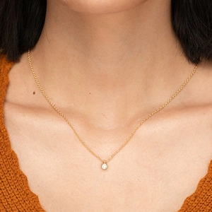 Close-up of minimalist S925 silver gold-plated necklace with a sparkling cubic zirconia stone