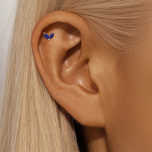Detailed shot of two marquise-cut blue lapis stones set in a gold cartilage stud earring