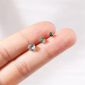 Three sizes of round moss agate stud earrings in silver prong settings held by hand