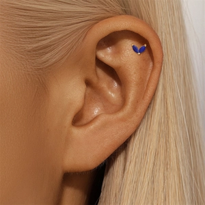 Close-up of gold ear cuff with blue marquise-cut stones on ear cartilage