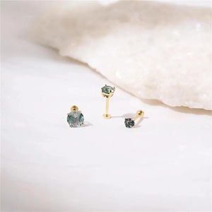 Macro detail of three gold-plated silver stud earrings with natural green moss agate stones