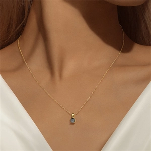 Detail van een minimalistische gouden S925 zilveren ketting met saffier hanger op een model