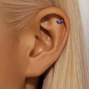 Macro view of geometric silver cartilage stud featuring two navy blue marquise gemstones
