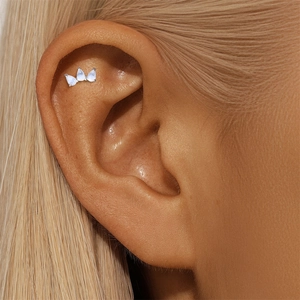 Macro view of a 925 sterling silver helix piercing with three teardrop moonstones