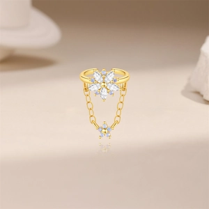 Dettaglio del polsino auricolare floreale in oro con zircone e opale blu