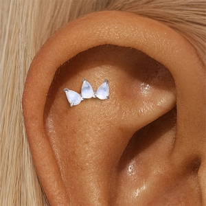 Macro shot of silver ear crawler featuring three pear-cut moonstones in claw settings