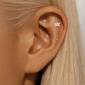 Detail view of a gold s925 silver sunflower stud earring with a dangling star