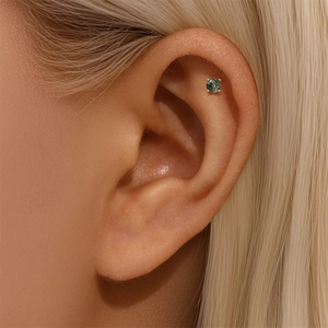 Detail of s925 gold-plated ear bone stud with natural green moss agate stone in claw setting