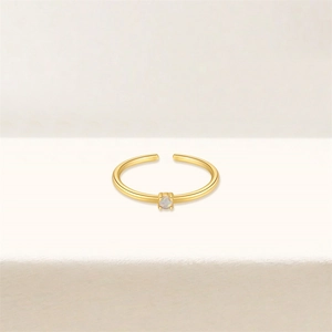 Detail of adjustable gold ring featuring a four-prong set opal stone on a sleek band