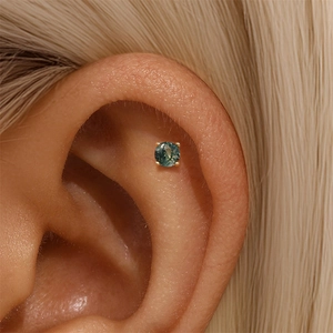 Detailed view of an S925 green moss agate stud earring worn on the ear bone cartilage