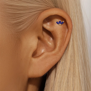 Macro shot of gold S925 crown clover cartilage stud with blue lapis lazuli stones