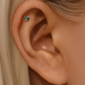 Close-up of s925 gold-plated ear bone stud with a natural green moss agate stone