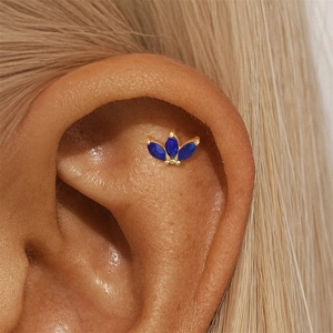 Close-up of s925 gold ear stud with navy lapis lazuli in a refined floral design