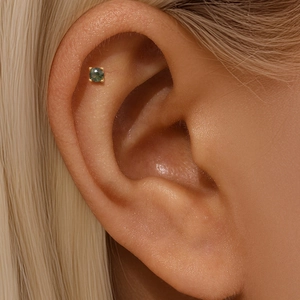 Close-up of a s925 gold-plated helix stud earring with a round green moss agate stone