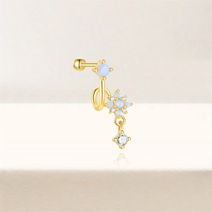 Detail of gold barbell stud with blue opal star design and clear zircon drop pendant