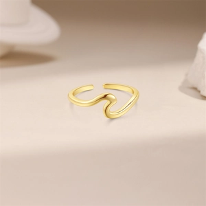 Macro detail of wave-shaped golden toe ring with adjustable open band on soft beige base