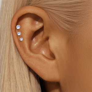 Macro shot of s925 sterling silver moonstone studs worn on a model's helix
