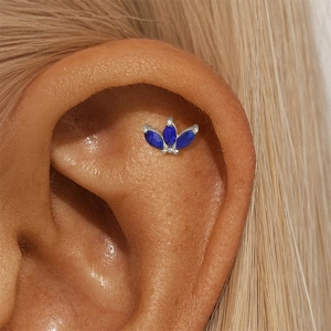 Macro detail of S925 silver lapis lazuli stud earring worn on the ear cartilage