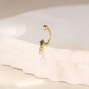 Detail of s925 gold-plated ear cuff with green marquise stone and clear teardrop gem